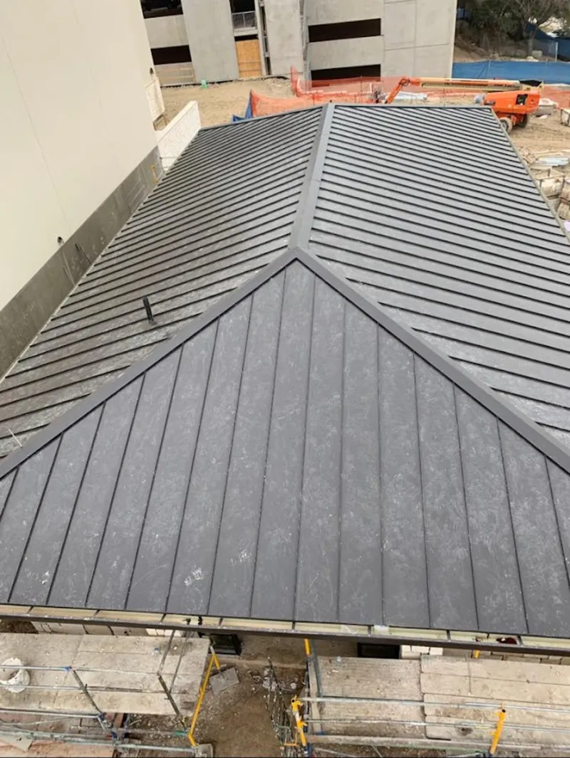 Commercial metal roof construction with crane equipment in Glendale Heights